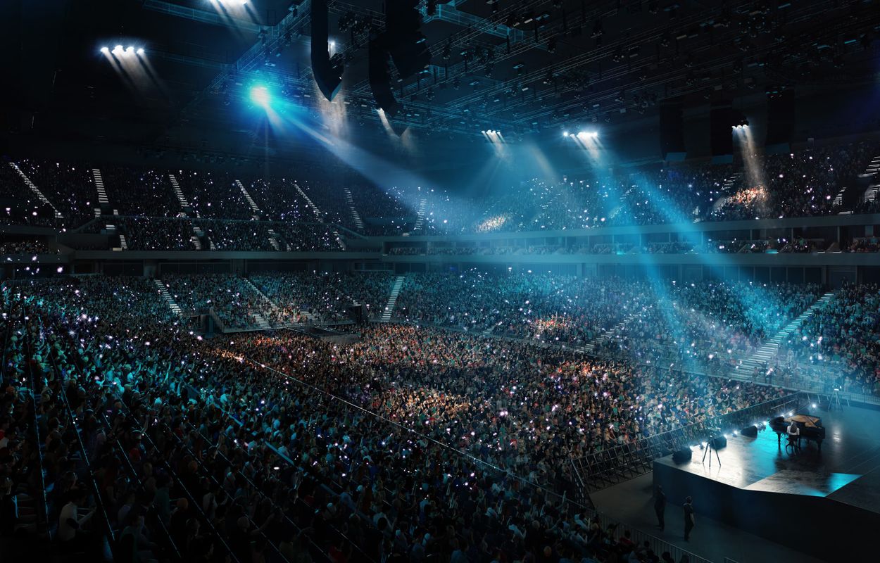 A CGI image of the inside of Co-op Live, showing a 23,500 strong crowd with a piano player on stage under 3 spotlights