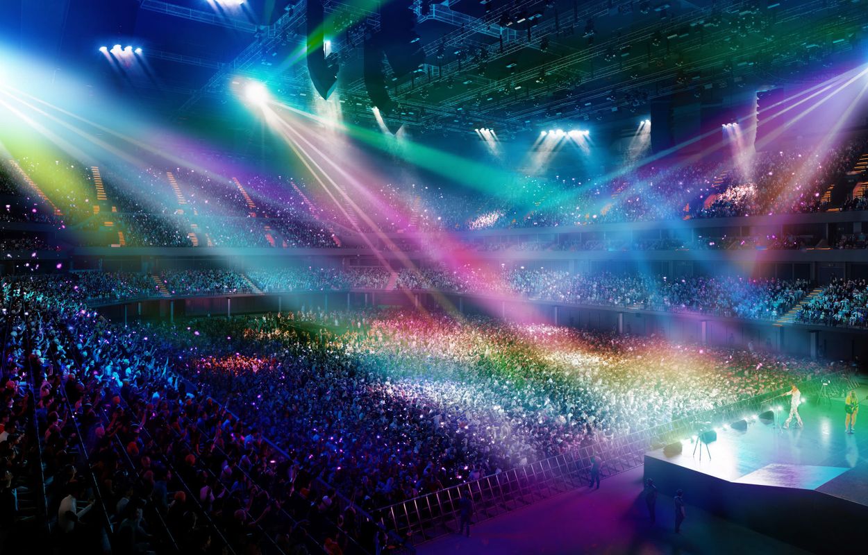 The Co-op Live bowl with rainbow coloured lighting across the full capacity crowd, with a performer on stage